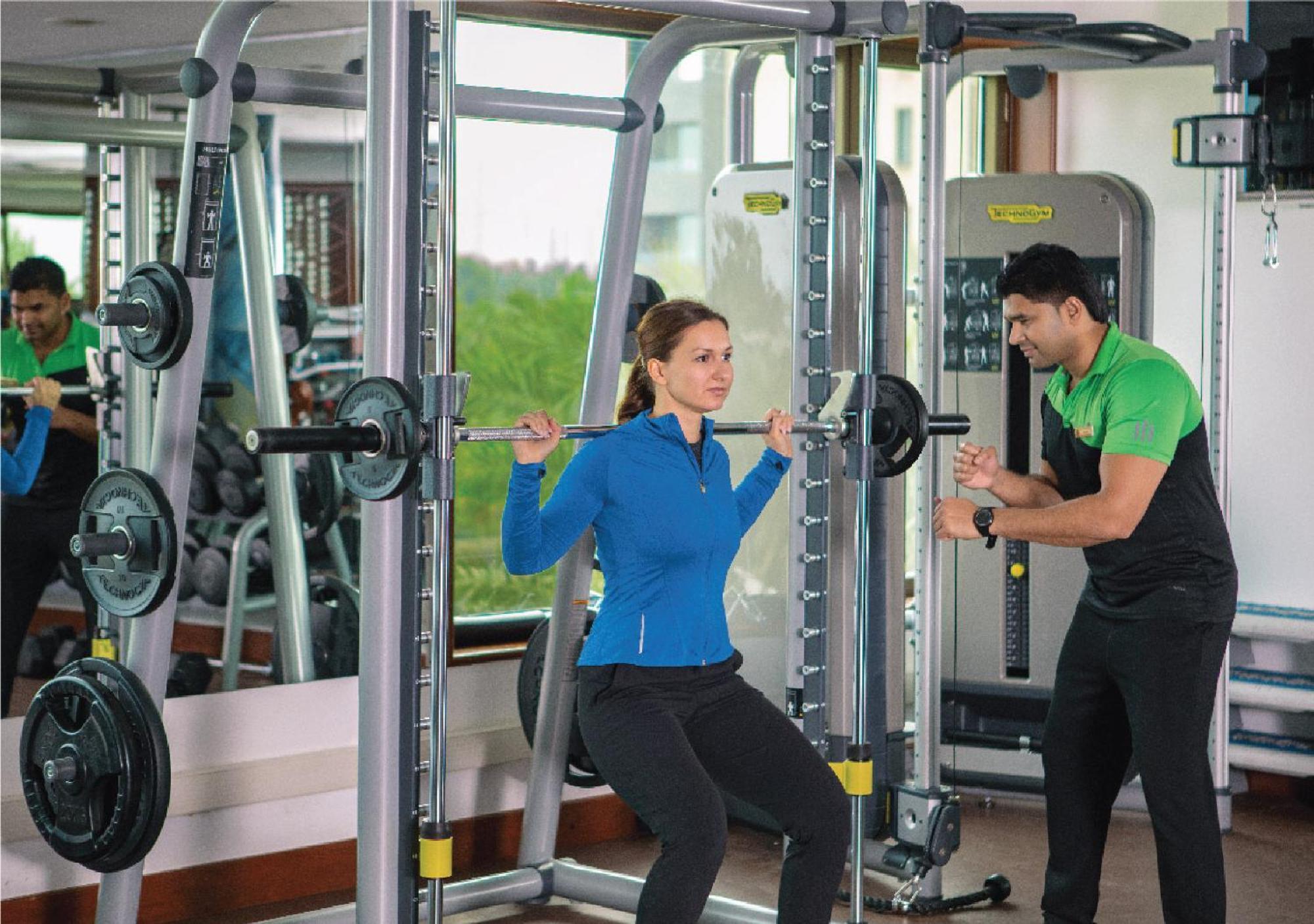 Jumeirah Messilah Beach Kuwait Кувейт Экстерьер фото A personal trainer assisting a woman with a weight training exercise